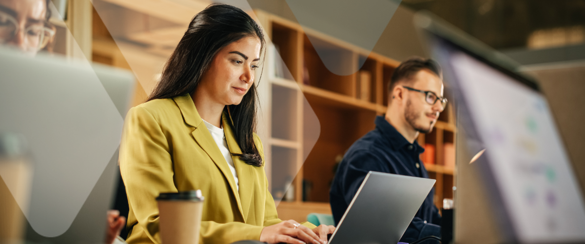 Employees working on laptops in an office setting, managing tasks related to health spending accounts benefits and modern group benefits planning.