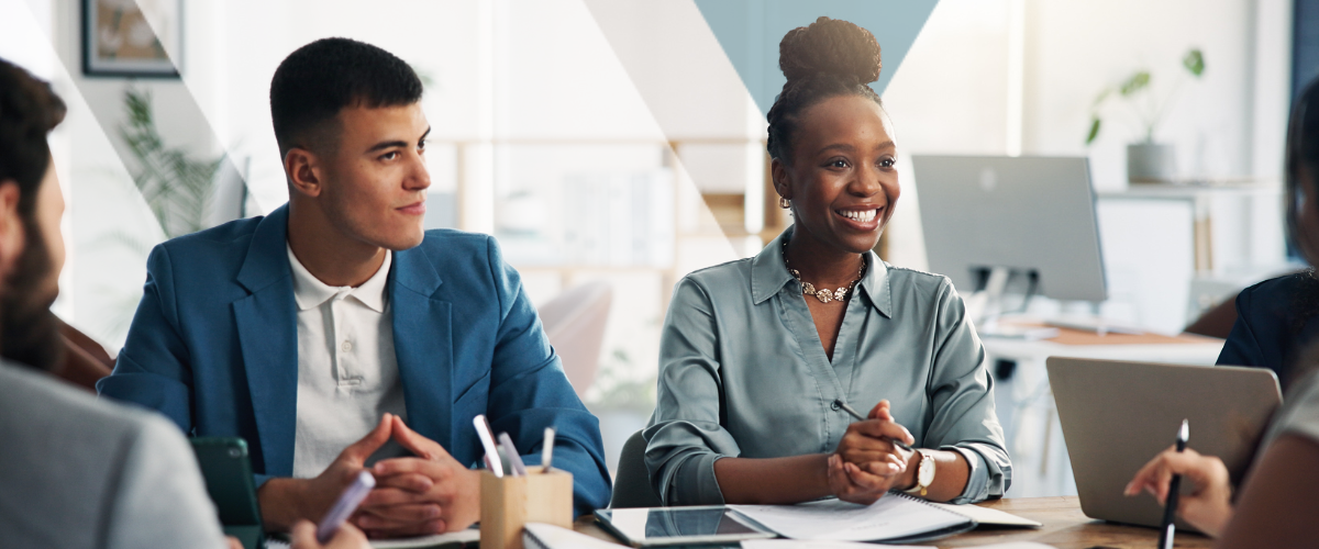 A diverse team of employees engaged in a workplace meeting, discussing their employee benefits plan ROI with a benefits advisor.