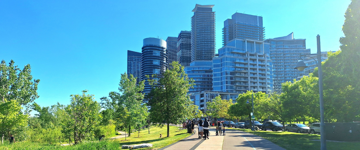 Exterior view of condo buildings along a park.